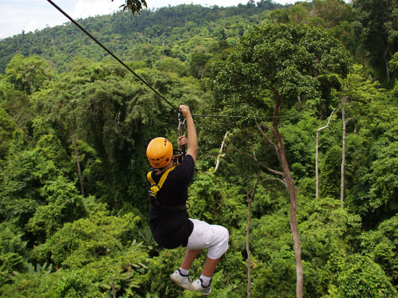Teenager ziplining through jungle