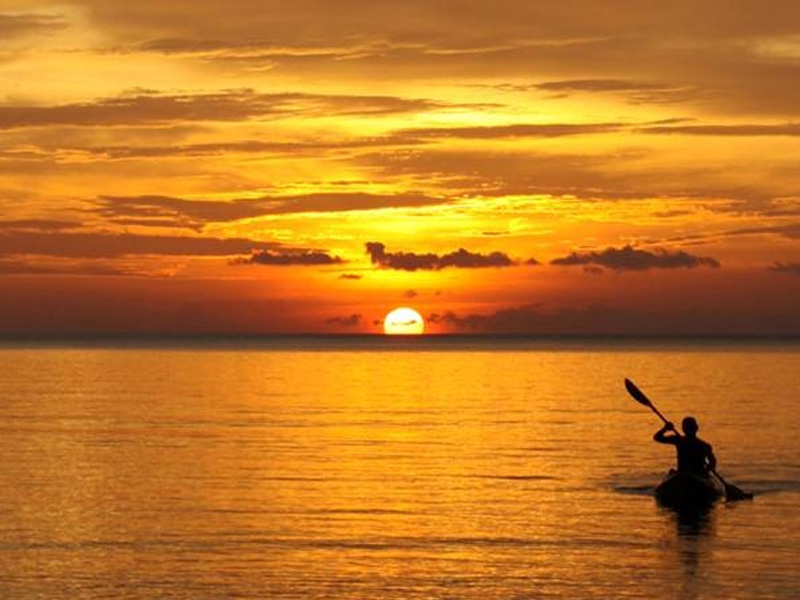 Man kayaking on the Gulf of Thailand during sunset
