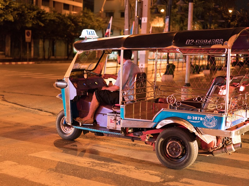 Tuk tuk driver in the streets of Bangkok at night
