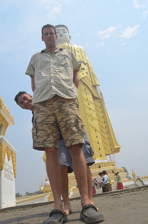 See Asia Differently founder Peter Jones posing in front of buddhist statue