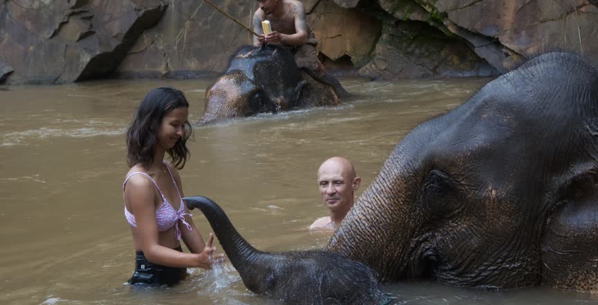 Family holiday In Asia Bathing Elephants A family bathing elephants in Southeast Asia